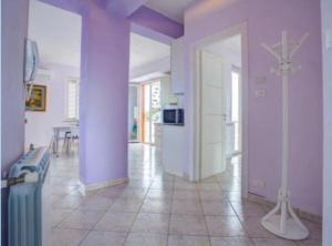a living room with purple walls and a kitchen at appartamento sul mare in Falcone