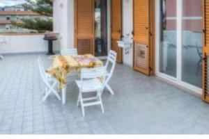 a patio with a table and chairs on a porch at appartamento sul mare in Falcone