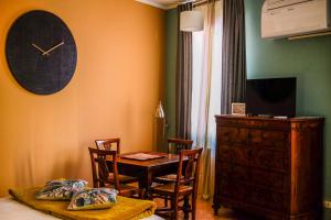 a dining room with a table and a clock on the wall at Canard Suite in Bologna