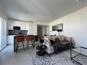 un salon avec un canapé et une cuisine dans l'établissement LE PARADIS BLANC, à Annecy