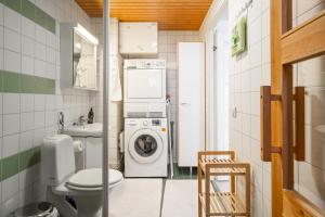 a small bathroom with a washing machine and a washer at Very nice apartment, 1BR, Private Sauna, Ocean view from balcony in Helsinki