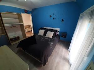 een slaapkamer met een zwart bed en een blauwe muur bij Superb vacancy at Patricks house 