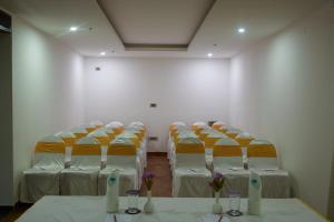 a room with rows of chairs and tables with flowers at Grand Continent Malleshwaram A Sarovar Portico Affiliate Hotel in Bangalore