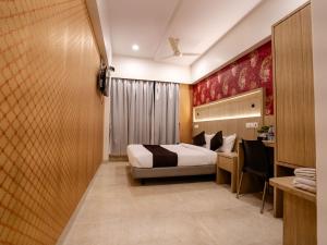a hotel room with a bed and a desk at Hotel Grand Seasons- Navi Mumbai in Navi Mumbai