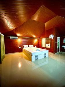 ein Schlafzimmer mit einem Bett und einer Holzdecke in der Unterkunft Misty Night Jungle Side Resort in Pulpally