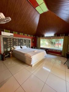 ein Schlafzimmer mit einem großen Bett und einer Holzdecke in der Unterkunft Misty Night Jungle Side Resort in Pulpally