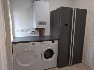 a kitchen with a refrigerator and a washing machine at Trade Digs Ryeleaze Road in Stroud