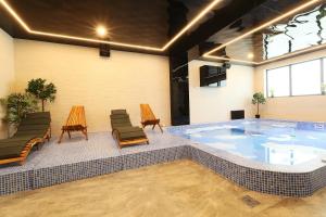 a large swimming pool with chairs and a table at Hotel Artemis in Oradea