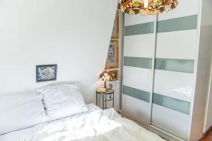 a bedroom with a white bed and a chandelier at Apartament Wiosenny in Szczecinek
