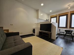uma sala de estar com um sofá e uma televisão de ecrã plano em Magnifico apartamento en Canelas em Portonovo