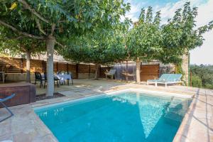 a swimming pool in a yard with a table and chairs at Majordoms - Cal Sabater in Las Escaulas