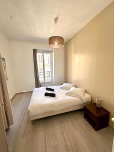 een slaapkamer met een groot wit bed en een raam bij 11 Trachel - Charmant T2 spacieux à proximité de gare Thiers in Nice