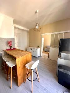 een keuken en een woonkamer met een houten tafel en stoelen bij 11 Trachel - Charmant T2 spacieux à proximité de gare Thiers in Nice