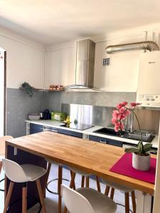 een keuken met een houten tafel in een keuken bij 11 Trachel - Charmant T2 spacieux à proximité de gare Thiers in Nice