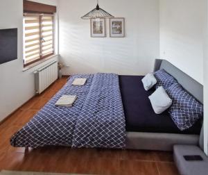 a bedroom with a bed with a blue comforter at Apartman Central Square in Gospić