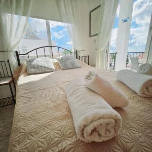 two beds in a bedroom with a large window at Villa Athena in Peyia