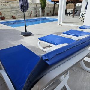 two blue and white chairs next to a swimming pool at Villa Athena in Peyia