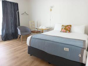 a bedroom with a bed and a desk and a chair at Melville Guest House near Waikato Hospital in Hamilton