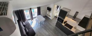 Design Loft Monteponi في تورينو: غرفة معيشة بها أريكة وتلفزيون