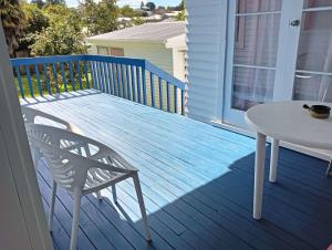 uma mesa branca e uma cadeira num alpendre em Melville Guest House near Waikato Hospital em Hamilton