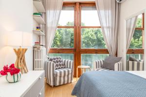 a bedroom with a bed and two chairs and a window at Lungarno del Tempio River View by 360Rentals in Florence