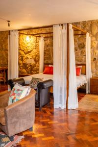 - une chambre avec un lit, une chaise et un canapé dans l'établissement Zereniti House, à Muyaka