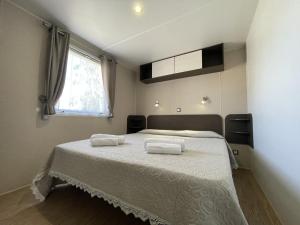 a bedroom with a bed with two towels on it at Campeggio Villaggio Sos Flores in Tortolì