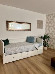 ein weißes Bett in einem Zimmer mit Spiegel in der Unterkunft Schöne Ferienwohnung im Schwarzwald in Bad Herrenalb