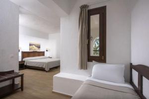 a hotel room with two beds and a mirror at Hersonissos Village Hotel & Bungalows in Hersonissos