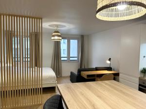 Sala de estar con cama y mesa en Appartement place de la république - Lille en Lille