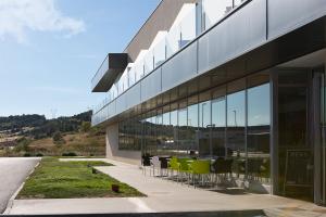 un edificio con mesas y sillas delante de él en NRuta Ponferrada en Bembibre