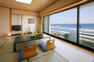 a living room with a view of the ocean at Kamogawa Grand Hotel in Kamogawa