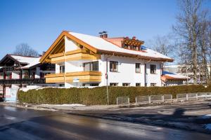 a house with a snow covered roof on a street at Haus Alpgaustraße - Ferienhäuser Alpenglück in Oberstdorf
