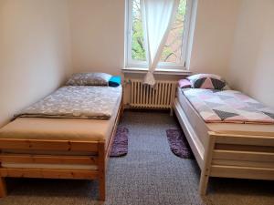2 łóżka pojedyncze w pokoju z oknem w obiekcie Perfect Resting Rooms w Bremie