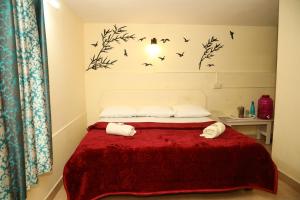 a bedroom with a bed with birds on the wall at DASWAL GARDEN HOME in Madikeri