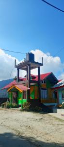 una casa colorida con un cartel encima en Neora valley eco hut's Kolakham, en Lava