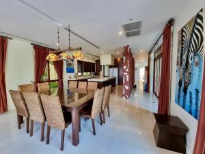 a dining room with a wooden table and chairs at Amatapura Beachfront Villa 12, SHA Certified in Ao Nam Mao
