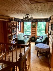 ein Wohnzimmer mit einer Treppe in einem Blockhaus in der Unterkunft Cottage PolyaNitsa окремий котедж з каміном in Bukowel