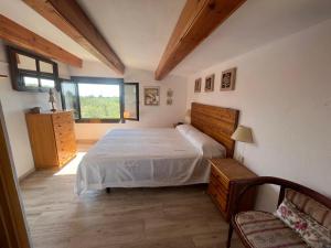 a bedroom with a bed and a window and a chair at Villa Sergi in Les tres Cales +17 photos