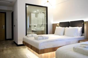 パムッカレにあるPamukkale Kaya Thermal Spa Hotelのホテルルーム 白いシーツ付きのベッド2台付