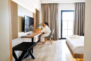 a man sitting at a desk in a hotel room at Pamukkale Kaya Thermal Spa Hotel in Pamukkale