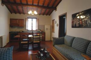 een woonkamer met een bank en een tafel en een keuken bij Comiti Farmhouse Apt Venere in Montaione