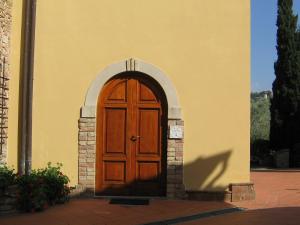 a wooden door on a building with an arch at Comiti Farmhouse Apt Bondone in Montaione