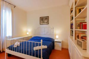 ボローニャにあるCantarana Apartmentsのベッドルーム(青いベッド1台、本棚付)
