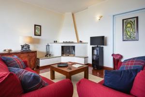 a living room with two red couches and a fireplace at Orizzonte Apartment Amazing Sea View in Pozzallo