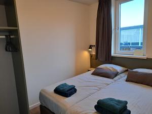 een slaapkamer met een bed met 2 kussens erop bij 107,5 Nieuw appartement met sauna in Westkapelle