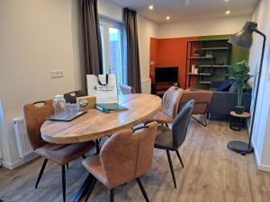 een woonkamer met een houten tafel en stoelen bij 107,5 Nieuw appartement met sauna in Westkapelle