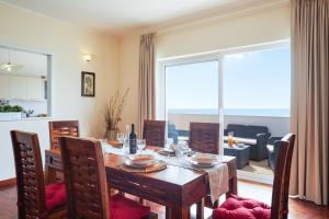 a dining room with a table and a large window at Orizzonte Apartment Amazing Sea View in Pozzallo
