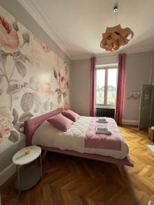 um quarto com uma cama grande e um cobertor rosa em La Parenthèse Fléchoise, Chambre Agathe em La Flèche