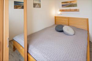 ein Schlafzimmer mit einem Bett mit einem Holzrahmen in der Unterkunft Friesenstübchen in Dornumersiel